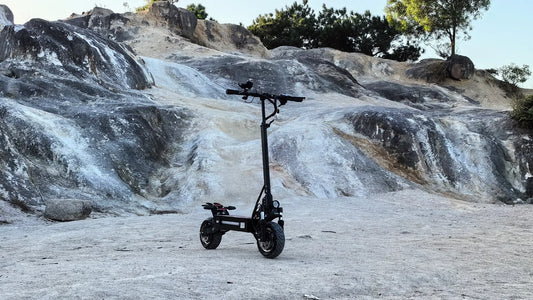 Boyueda high-performance electric scooter parked beside a mountain road during outdoor riding adventure