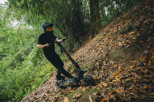 KuKirin electric scooter riding uphill on an outdoor road