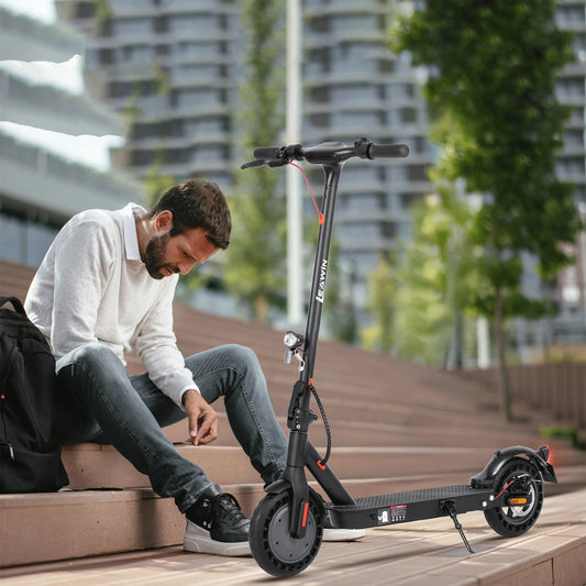 Foldable electric scooter parked beside an office entrance after commuting